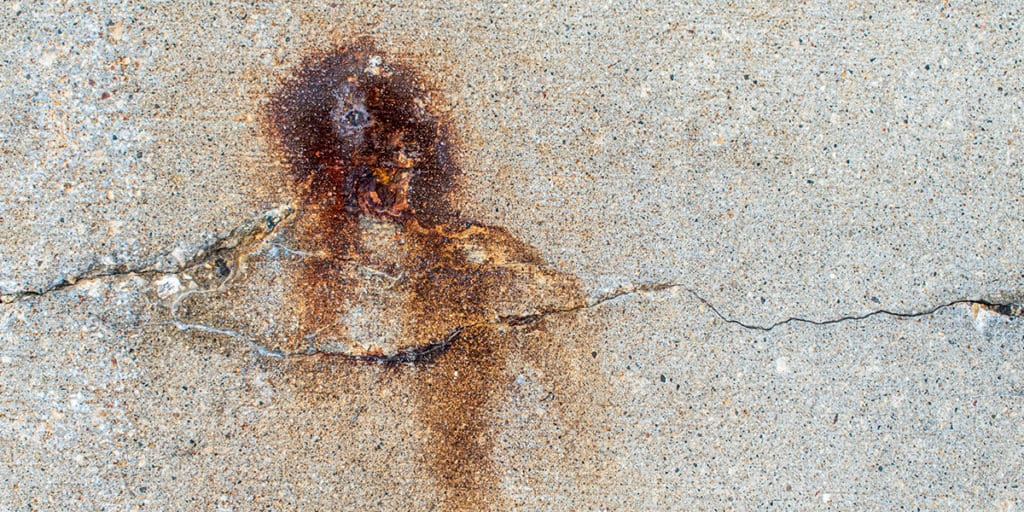 Corrosion stains showing through concrete crack - photo by Jarrod Erbe on Unsplash