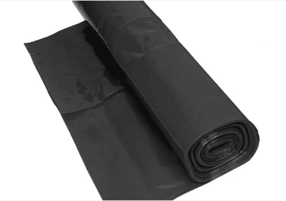 A rolled-up black landscape fabric sheet used for ground covering in landscaping projects.